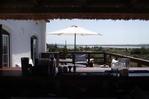 a table with an umbrella on top of a patio at Sunshine Hostel - from 18 to 40 years only - Youth Accomodation in Foz do Arelho