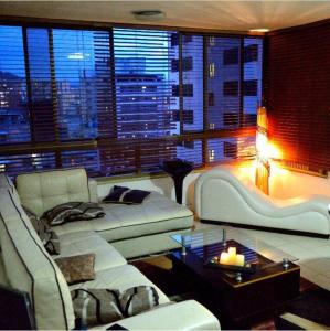 a living room with a white couch and a large window at Confortable apto tipo Suite/ Turismo Relax in Caracas
