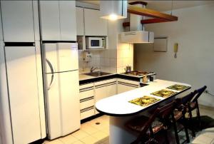 uma cozinha com armários brancos e um frigorífico branco em Confortable apto tipo Suite/ Turismo Relax em Caracas