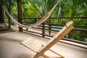 a hammock in a resort with palm trees at Hotel Buenavista Bacalar Jungle Experience in Bacalar