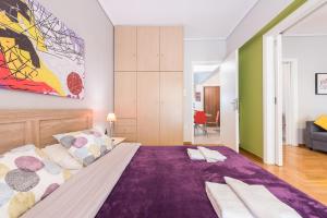 アテネにあるZenios Ippokratis-Comfort & style, Athens downtownのベッドルーム(紫の毛布を使用した大型ベッド1台付)