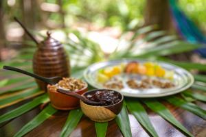 une table avec une assiette de nourriture et une assiette de fruits dans l'établissement Hotel Buenavista Bacalar - Yoga & Meditation Included, à Bacalar