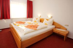 ein Schlafzimmer mit einem großen Bett und orangefarbenen Bademänteln in der Unterkunft Ferienwohnungen Thorsten Fründt in Prerow