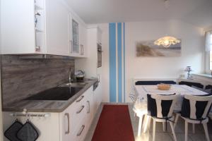 a kitchen with a sink and a table with chairs at Ferienwohnungen Thorsten Fründt in Prerow +19 photos