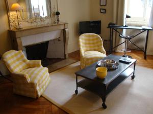 a living room with two chairs and a fireplace at L'Annexe Apparthôtel du 11 C, 3 étoiles in Besançon