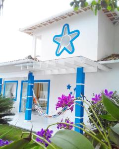 Una casa blanca con una estrella azul. en Estrela Azul Guest House Búzios, en Búzios