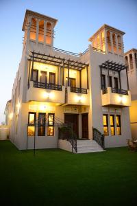 a large white house with a lawn in front of it at Kaleidoscope in Ajman 