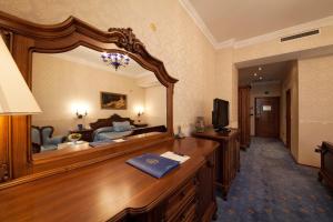 a room with a large mirror in a hotel room at Grand Hotel London in Varna City