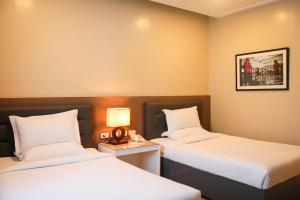 um quarto de hotel com duas camas e um candeeiro em Iloilo Gateway Hotel and Suites em Iloilo City