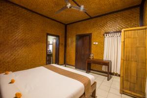 a bedroom with a bed and a table in it at Pondok Permata Homestay in Ubud