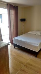 Un pat sau paturi într-o cameră la Casa Costa Azul - praça da Baleia