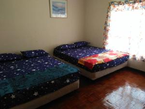 une chambre avec deux lits et une fenêtre dans l'établissement Marina View, Teluk Kemang, PD, à Port Dickson 15 autres photos