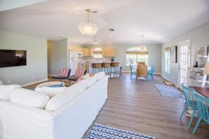 a living room with a white couch and a kitchen at Stunning Newly Designed and Renovated Home seconds to the Gulf Of Mexico in Sanibel