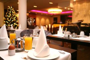 a table with white napkins and a christmas tree in a restaurant at Hotel Favor in Düsseldorf