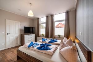 two beds in a bedroom with blue towels on them at Altstadtvilla in Borkum