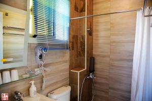 un bagno con doccia, wc e lavandino di Cicada said Greece Homestay a Jinning
