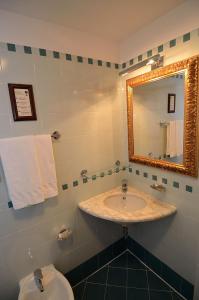 a bathroom with a sink and a mirror and a toilet at Locanda La Corte in Venice