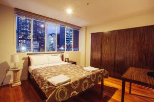 sypialnia z łóżkiem i dużym oknem w obiekcie YTI Garden Hotel w Melbourne