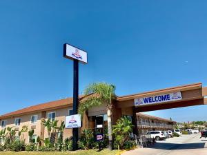 um sinal de boas-vindas em frente a um edifício em Buena Park Inn em Anaheim