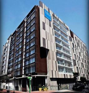 un gran edificio con un cartel de hotel en Moderno y funcional departamento Miraflorino en Lima
