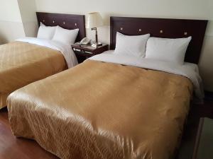 Postel nebo postele na pokoji v ubytování SunWang Hotel