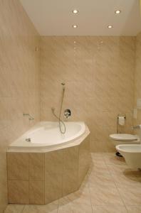 a bathroom with a bath tub and a toilet at Hotel Mazowiecki in Łódź