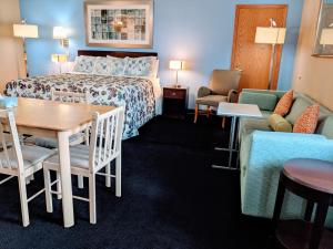 une chambre d'hôtel avec un lit, une table et des chaises dans l'établissement Executive Inn, à Thomson