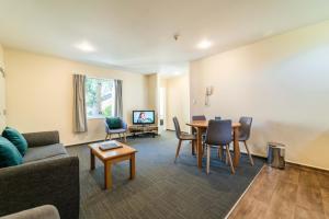 una sala de estar con un sofá y una mesa en City Centre Motel, en Christchurch