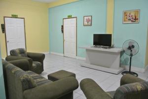 uma sala de espera com duas cadeiras e uma televisão em Kawoq Hostel em San Ignacio
