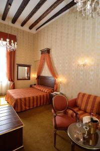 a hotel room with a couch, chair, table and lamps at Locanda La Corte in Venice