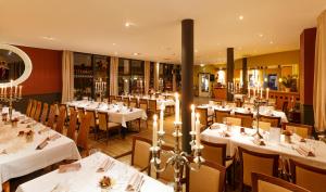 un comedor con mesas y sillas blancas en Hotel Antares, en Halberstadt