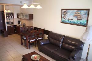 a living room with a couch and a table at Apartament Kolonialny Olympic Park in Kołobrzeg