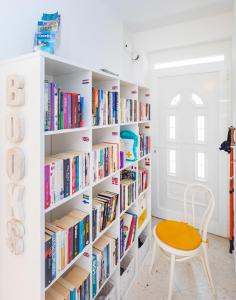 una habitación con estanterías blancas llenas de libros en Apartments Mirela, en Mlini
