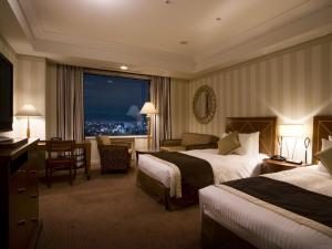 a hotel room with two beds and a view of a city at Imperial Hotel Osaka in Osaka +185 photos