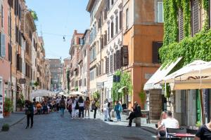Un grupo de personas caminando por una calle con edificios. en Art Atelier Borgo, en Roma