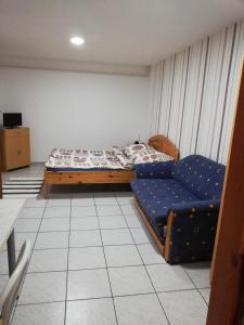 アバッザロークにあるNorbi Apartmanokのベッドルーム(ベッド1台、ソファ付)