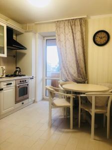 cocina con mesa, sillas y ventana en Classic Apartment en Boryspilʼ