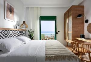 ein Schlafzimmer mit Bett, Schreibtisch und Fenster in der Unterkunft Beachfront Villa on Crete - Kirvas, member of Pelagaios Villas in Koutsounári