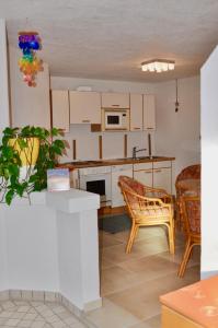 uma cozinha com armários brancos e uma mesa e cadeiras em Familien Appartement „Im Landhaus“ em Gaal