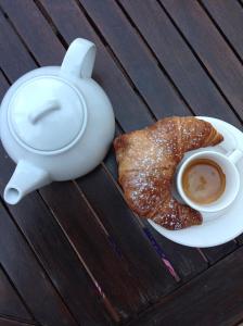 a cup of coffee and a croissant on a table at Campo Reale country rooms in Pachino