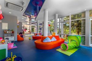 a childrens play room with orange and green furniture at Hotel Malin in Malinska