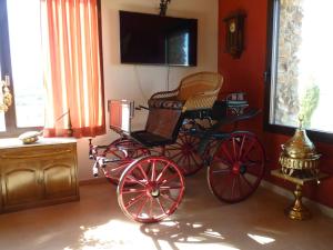 a red carriage in a room with a tv at Casa Rural Yeguada Jimenez Latorre in Fernancaballero