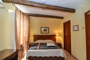 Schlafzimmer mit einem Bett mit einem Kopfteil aus Holz in der Unterkunft S.Andrea degli Armeni Dimora di Charme in Taranto