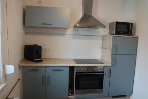 a small kitchen with a stove and a refrigerator at FeWo Lollar - wohnen auf Zeit in Lollar