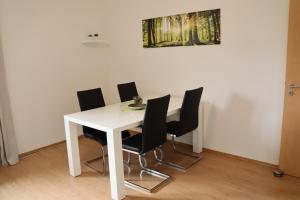 a white dining room table with black chairs at FeWo Lollar - wohnen auf Zeit in Lollar