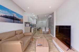a living room with a couch and a table at Modern 2 Bedroom Apartment in St Julians in St. Julianʼs