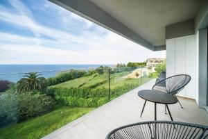 a balcony with a chair and a view of the ocean at Boutique Ocean Terrace Luxury - SSHOUSING in San Sebastián
