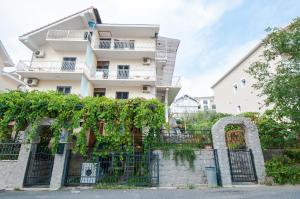an apartment building with vines on a fence at Apartments Milena in Tivat