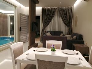 a living room with a table and chairs and a couch at Han River Chalets in Taif