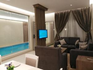 a living room with a couch and a tv at Han River Chalets in Taif